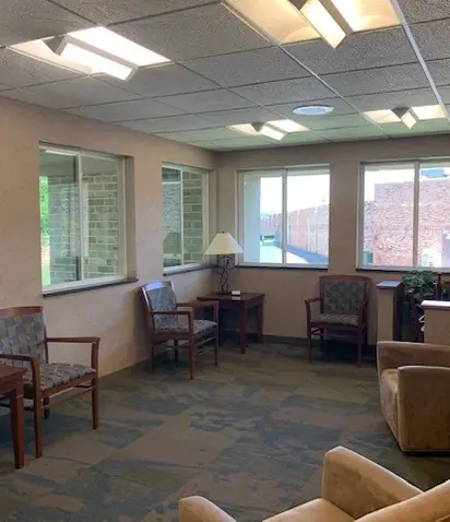 The Tonka Smiles waiting room, with armchairs and tables by the windows.